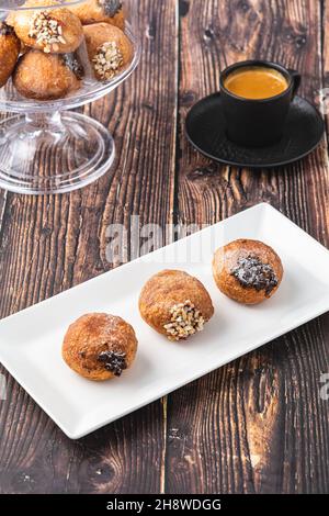 Bombolon oder Bomboloni ist ein italienisches gefülltes Donut- und Snackfutter. Deutsche Krapfen - Krapfen oder berliner - gefüllt mit Marmelade und Schokolade Stockfoto