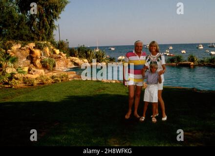 Gunter Sachs und Ehefrau Mirja und Sohn Claus Alexander im Garten des Anwesens in St. Tropez, Frankreich 1980er Jahre. Gunter Sachs, seine Frau Mirja und Sohn Claus Alexander im Garten ihres Hauses in St. Tropez, Frankreich 1980s. Stockfoto