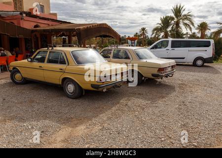 Provinz Errachidia, Marokko - 23. Oktober 2015: Großer Parkplatz für Taxis. Alte Mercedes-Benz Autos stehen vor einem Café auf der Autobahn. Stockfoto