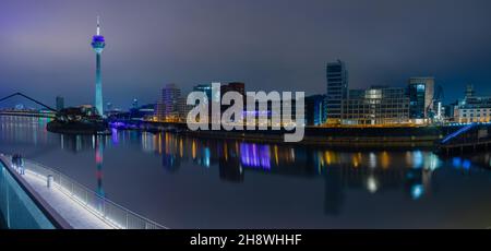 Panorama-Nachtansicht des Düsseldorfer Medienhafens vom Hyatt Hotel aus, mit Blick auf den Fernsehturm und die von Frank Gehry entworfene Uferpromenade Stockfoto