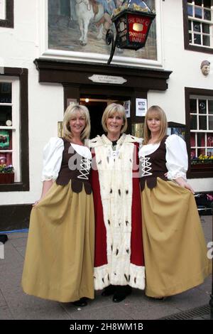 Ayr, Ayrshire, Schottland. Im Rahmen des lokalen Festivals, das den schottischen Dichter Robert Burns feiert und das berühmte Gedicht „The Tale of Tam o Shanter“ reenactment, bei dem ein betrunkener Reiter vom öffentlichen Haus auf seinem Pferd nach Hause geht. : Tam o Shanter Bar Maids Vivian Scrace und Anne Scott kleiden sich in einem 18th-Jahrhundert-Kostüm und posieren mit dem Provost von Ayr Winifred Sloan Stockfoto