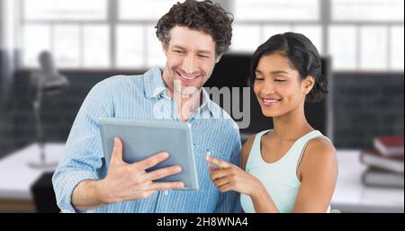 Digitales zusammengesetztes Bild einer lächelnden Geschäftsfrau, die auf ein digitales Tablet zeigt, das von einem Geschäftsmann gehalten wird Stockfoto