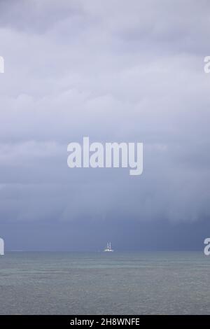 Segeln in den kommenden Sturm. Segelboot bei schlechtem Wetter segeln Meer eröffnet. Segelyacht unter schweren Wolken Himmel. Stockfoto