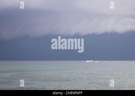 Segeln in den kommenden Sturm. Segelboot bei schlechtem Wetter segeln Meer eröffnet. Segelyacht unter schweren Wolken Himmel. Stockfoto