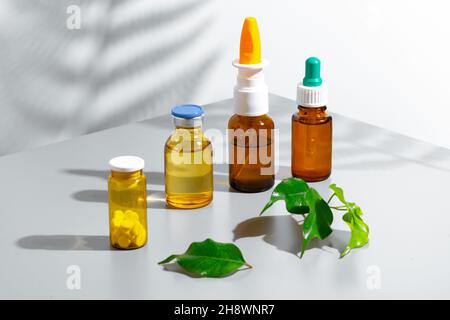 Kräuterextrakte in kleinen Flaschen auf grauem Hintergrund Stockfoto