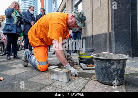 02. Dezember 2021, NRW, Düsseldorf: Zwei zuvor gestohlene Stolpersteine zum Gedenken an das Schicksal des Ehepaars Berta und Max Back werden wieder eingesetzt. Anfang November waren die beiden Stolpersteine im Stadtteil Pempelfort gewaltsam aus der Straße gerissen worden. Zwei Wochen später entdeckte ein Bürger die gestohlenen Steine in einem Park und brachte sie zur Polizei. Foto: Malte Krudewig/dpa Stockfoto