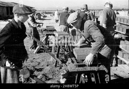 Okolice Warki, 1946-01-01. Zgodnie z programmem Odbudowy Gospodarczej Terenów Zniszczonych po II wojnie œwiatowej, przeprowadzane s¹ prace budowlane i porz¹dkowe we wsiach po³o¿Onych w pasie zniszczeñ. NZ. produccja cegie³. po/ms PAP/Jerzy Baranowski Warka, 1. Januar 1946. Entsprechend dem UN-Programm für den wirtschaftlichen Wiederaufbau zerstörter Gebiete helfen nach WW2 Bürger beim Wiederaufbau und der Organisation von Dörfern in zerstörten Gebieten. Abgebildet: Ziegelherstellung. po/ms PAP/Jerzy Baranowski Stockfoto