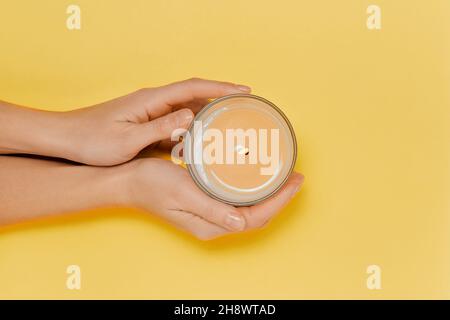 Weibliche Hände mit aromatischer Duftkerze. Spa Stockfoto