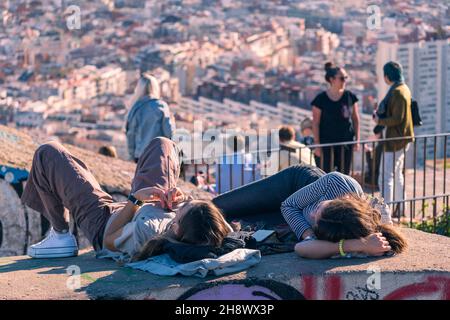 BARCELONA, SPANIEN - 30. Nov 2021: Zwei junge Frauen schauen sich den Blick von den Bunkern del Carmel auf den klaren Himmel in Barcelona, Spanien, 30th 202 an Stockfoto