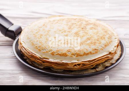 Stapel von französischen Crepes in der Pfanne auf hölzernen Küchentisch Stockfoto