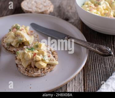 Fitness-Mahlzeit und proteinreiches Essen mit einem fettarmen Eiersalat, serviert mit braunem Reiskracker auf einem Teller Stockfoto