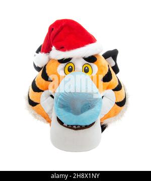 Spielzeug Tiger Kopf in roten weihnachtsmann Hut und blaue schützende medizinische Maske, zu isolieren. Konzept für Neujahr und Geburt 2022 während der Coronavirus-Epidemie Stockfoto