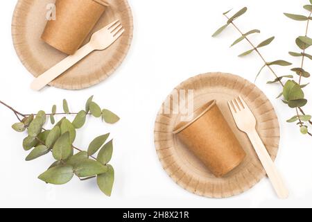 Einwegbecher, Teller und Holzbesteck auf weißem Hintergrund Stockfoto
