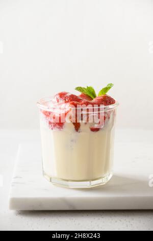 Layered Erdbeere Kleinigkeit Dessert Cookie Savoyardi, Mascarpone und Schlagsahne auf weißem Hintergrund. Vertikale Ausrichtung. Nahaufnahme. Stockfoto