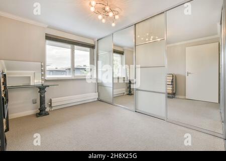 Leeres geräumiges Zimmer mit Schrank in der Nähe geschlossener Tür in moderner Wohnung Stockfoto