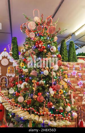 Tannenbaum geschmückt zu Weihnachten mit Kugeln, Lichtern, Lebkuchen und Süßigkeiten. Stockfoto