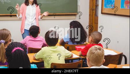 Digitaler Verbund von Fragezeichen über Lehrer, der den Schülern erklärt, die im Klassenzimmer sitzen Stockfoto