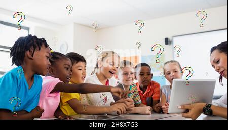 Digitale Zusammenstellung von Fragezeichen über Lehrer, die den Schülern im Klassenzimmer einen Tablet-pc zeigen Stockfoto