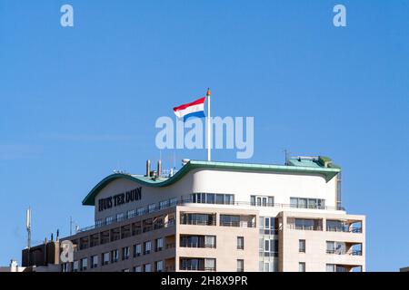 NOORDWIJK, NIEDERLANDE - 26. Feb 2018: Die niederländische Flagge winkt bei starkem Wind auf dem ikonischen Huis ter Duin Hotel an der niederländischen Küste in Noordwijk, Ne Stockfoto