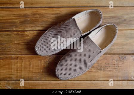 Leder-Herrenschuhe mit Perforation auf dem Holzhintergrund. Stockfoto