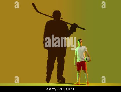 Konzeptuelles Image mit einem jungen Mann, der von einer neuen zukünftigen Sportkarriere träumt. Schatten eines starken männlichen Eishockeyspielers auf dunkelgrünem Hintergrund Stockfoto