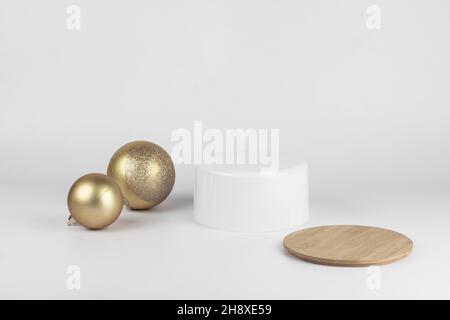 Leere runde weiße Podium und goldene Weihnachtskugeln für Produktpräsentation weißen Hintergrund. Minimaler Weihnachts-Kosmetik-Mockup, Kopierplatz. Stockfoto