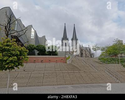 Treppen hinauf zum Kölner Dom entlang des Museums für moderne Kunst Ludwig an einem bewölkten Tag in Köln, Ge Stockfoto