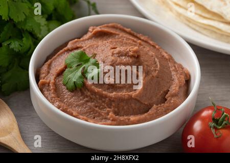 Schüssel mit mexikanisch braun gebratenen Bohnen Paste aus nächster Nähe Stockfoto