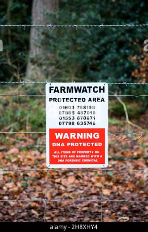 Farmwatch-Schild mit geschütztem Bereich auf einem Zaun um Norfolk Woodland. Stockfoto