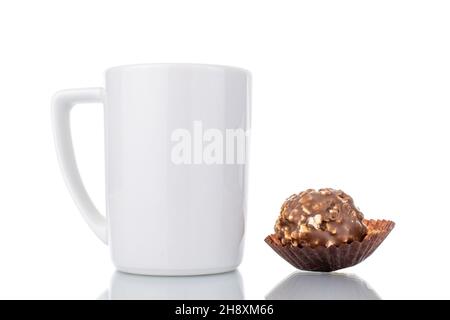 Eine süße Schokolade mit Nüssen in einem weißen Keramikbecher, Nahaufnahme, isoliert auf Weiß. Stockfoto