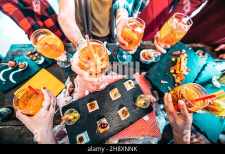Die Leute toasten bunte Spritz Drinks - trendige Freunde, die Spaß haben, zusammen Cocktails zu trinken zur Happy Hour am Barbuffet Stockfoto