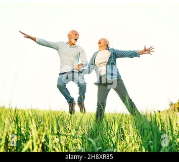 Frau Mann im Freien Senior paar glücklich Lifestyle Ruhestand zusammen Liebe springen Spaß Natur reifen Stockfoto