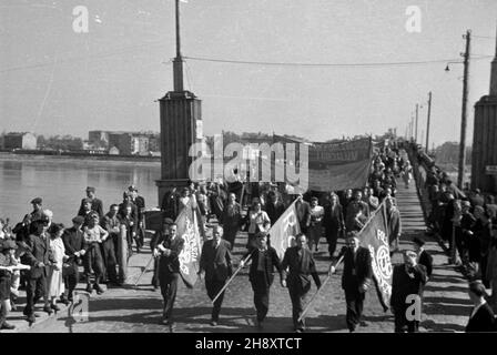 Warszawa, 1946-05-01. Uczestnicy pochodu w drodze na wiec pierwszomajowy zorganizowany na Placu Teatralnym. W g³êbi prowizoryczny most pontonowy na Wiœle w pobli¿U dzisiejszego mostu Œwiêtokrzyskiego. ps/pp PAP/Jerzy Baranowski Warschau, 1. Mai 1946. Die Teilnehmer des 1. mai-märzes machen sich auf den Weg zur 1. Mai-Kundgebung auf dem Teatralny-Platz. Im Hintergrund eine temporäre Pontonbrücke auf der Weichsel. ps/pp PAP/Jerzy Baranowski ps/pp PAP/Jerzy Baranowski Stockfoto