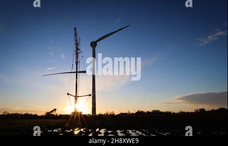 02. Dezember 2021, Schleswig-Holstein, Brunsbüttel: Das dritte Rotorblatt wird mit einem mobilen Kran auf einer Enercon-Windkraftanlage (E150) in einem Windpark zwischen Marne und Brunsbüttel montiert. Laut einer Studie könnten sich die Einsparungen von CO2 bis 2030 im Vergleich zu den bisherigen Plänen der Großen Koalition aufgrund der Wind- und Solarstrompläne der Ampelkoalition mehr als verdoppeln. Foto: Christian Charisius/dpa Stockfoto