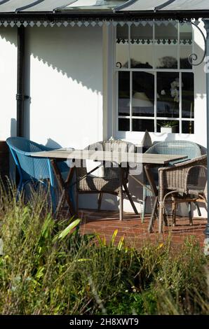 Lloyd Loom Stühle auf der Terrasse des Hauses im malerischen Küstendorf Bosham im Hafen von Chichester, in der Nähe von Chichester, West Sussex, England, Großbritannien Stockfoto