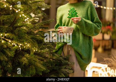 Frau hält Lebkuchen in Form eines Weihnachtsbaums Stockfoto