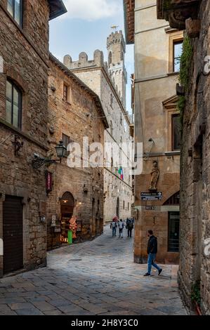 Volterra, Pisa - 2021. November 11: Die Menschen gehen durch die Straßen der Altstadt. Stockfoto
