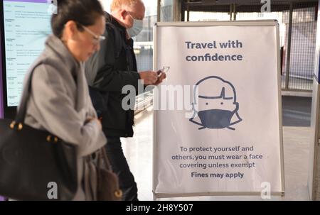 London, Großbritannien. 02nd Dez 2021. Pendler laufen am Schild „Wear Face Masks“ vorbei, an der Waterloo Station in London.in England sind Gesichtsbedeckungen im öffentlichen Nahverkehr sowie in Bahnhöfen wieder Pflicht geworden. Kredit: SOPA Images Limited/Alamy Live Nachrichten Stockfoto