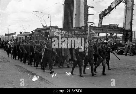 Warszawa, 1946-06-17. W sali teatru Roma przy ul. Nowogrodzkiej 49 rozpocz¹³ siê pierwszy zjazd cz³onków Polskiej Partii Socjalistycznej (PPS), uczestników walki zbrojnej z Niemcami. NZ. Przemarsz Alejami Jerozolimskimi uczestników zjazdu, grupa reprezentantów woj. Bydgoskiego mija ruiny Dworca G³ównego. mw PAP/Jerzy Baranowski Warschau, 17. Juni 1946. Der Kongress der Mitglieder der Polnischen Sozialistischen Partei (PPS) aus dem Jahr 1st, die am bewaffneten Kampf mit den Deutschen teilnahmen, begann im Roma-Theater in der Nowogrodzka-Straße 49. Im Bild: kongressteilnehmer marschieren auf Jerozolimskie Avenue, eine Gruppe von Stockfoto