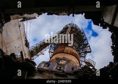 Alte rostige verlassene Rektifikationskolonne, Ansicht von unten aus dem Loch. Stockfoto