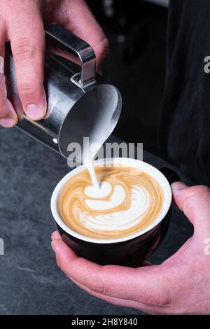 Making of Latte Art by Barista konzentriert sich auf Milch und Kaffee. Stockfoto