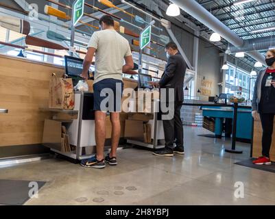 Kirkland, WA USA - ca. September 2021: Ansicht der Kunden, die in den Self-Checkout-Bahnen in einem Whole Foods-Supermarkt auschecken. Stockfoto