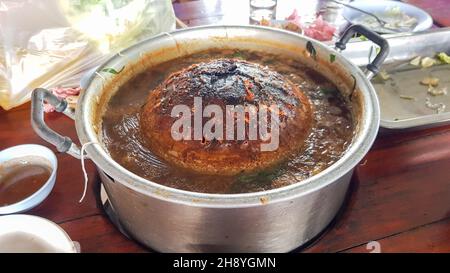 Das Buffet wird auf einem Holzkohlegrill in einer Pfanne gegrillt. Was auf der Pfanne blieb, war brennend schwarz. Im Thailändischen heißt es Moo Krata. Stockfoto