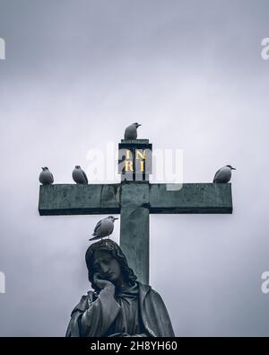 Szenische Aufnahme der Pieta-Statue auf der Karlsbrücke in Prag und der Vögel, die darauf sitzen