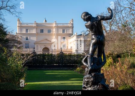 Blick auf die St John's Lodge, Regent's Park, London, Großbritannien, fotografiert an einem klaren Wintertag vom Rosengarten aus. Statue von Hylas im Vordergrund. Stockfoto