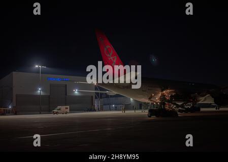 Flieger des Logistics Readiness Squadron 152nd laden Gepäck auf eine Omni Air International Boeing 777 auf der Nevada Air National Guard Base, Reno, Nevada, 28. November 2021. Mitglieder der Nevada Air National Guard sind in dieser Weihnachtszeit im Verantwortungsbereich des US Africa Command unterwegs, um Theater-Luftbrücke und Luftaufnahmen zu liefern. (USA Foto der Air National Guard von Airman First Class Thomas Cox) Stockfoto