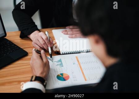 Verschiedene Geschäftsleute diskutieren den Finanzbericht in Diagrammen und Diagrammen aus der Nähe, Geschäftspartner analysieren allgemeine Verkaufsstatistiken Stockfoto