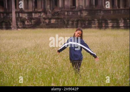 Eine schöne junge Mischrassenfrau (1/2 Burmesinnen, 1/4 Laoten, 1/4 Kambodschaner) genießt ihre Zeit in einem leeren und verlassenen Angkor Wat während der Coronavirus-Pandemie. Normalerweise beschäftigt mit internationalen Touristen, Angkor Wat ist seit über 1 & 1/2 Jahren verlassen wegen COVID - 19. Archäologischer Park Angkor, Provinz Siem Reap, Kambodscha. 16th. Oktober 2021. © Kraig Lieb Stockfoto