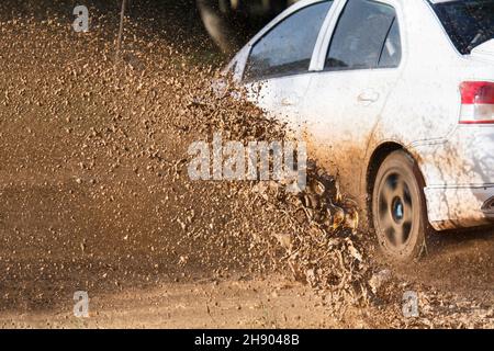 Schlammschutt spritzt aus einem Rallyewagen (Fokus auf Schlammdebis) Stockfoto