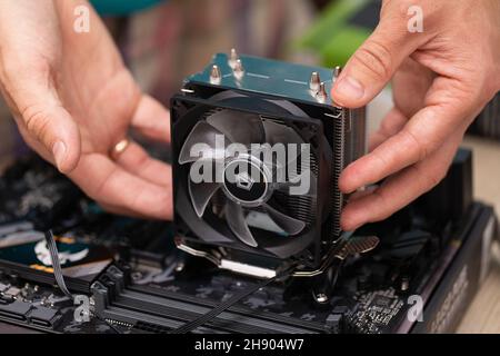 Techniker, der Aluminium-Kühlkörper installiert, installiert ihn an der Computerplatine für Kühlchips. Luftkühlsystem des Desktop-Computer-Prozessors. Russ Stockfoto